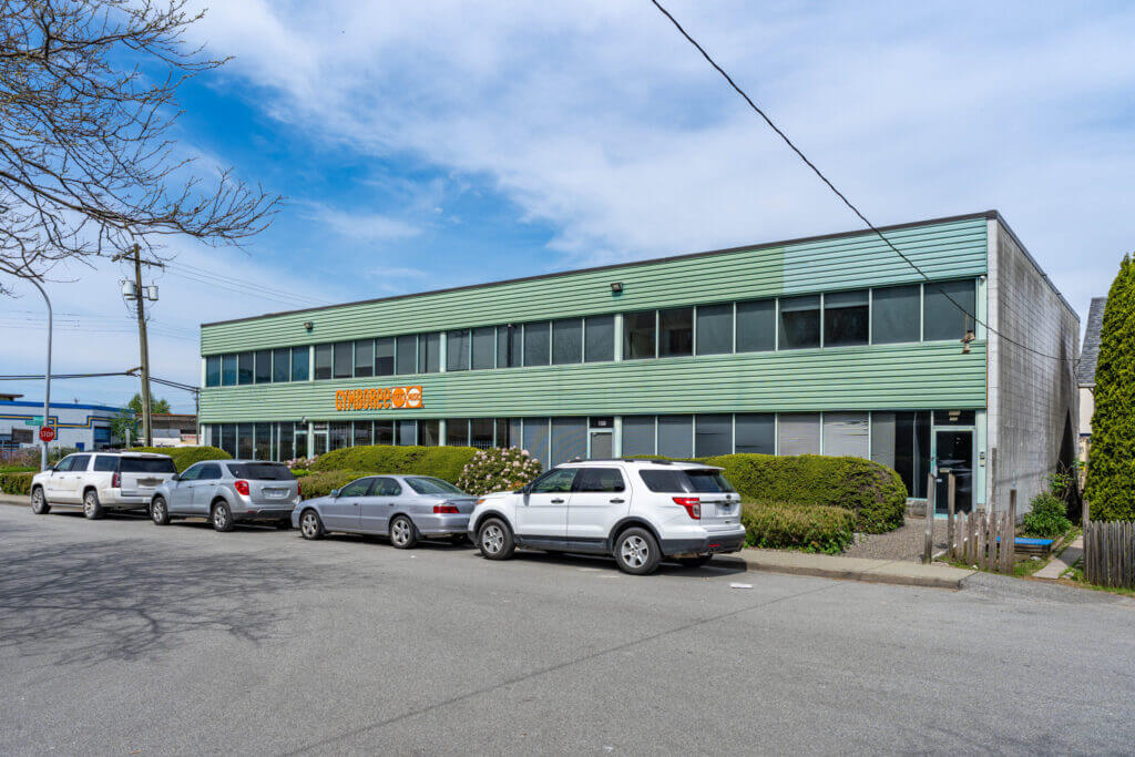 Rear exterior of 8771 Douglas Street showing parking and upper windows