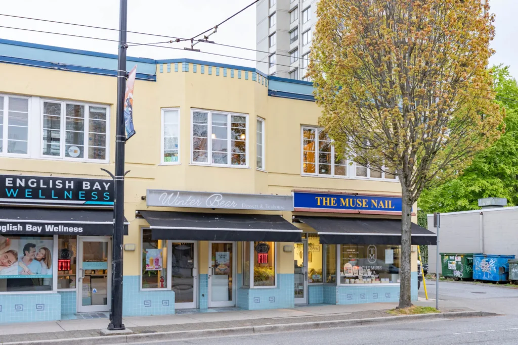 Close-up of 903 Denman Street ground-floor retail units with awnings and signage
