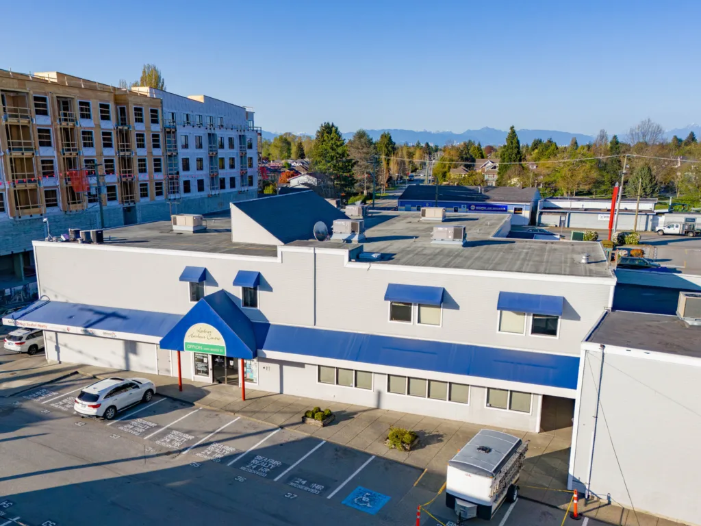 Ladner Harbour Centre office entrance with blue peaked awning and parking stalls in Delta BC