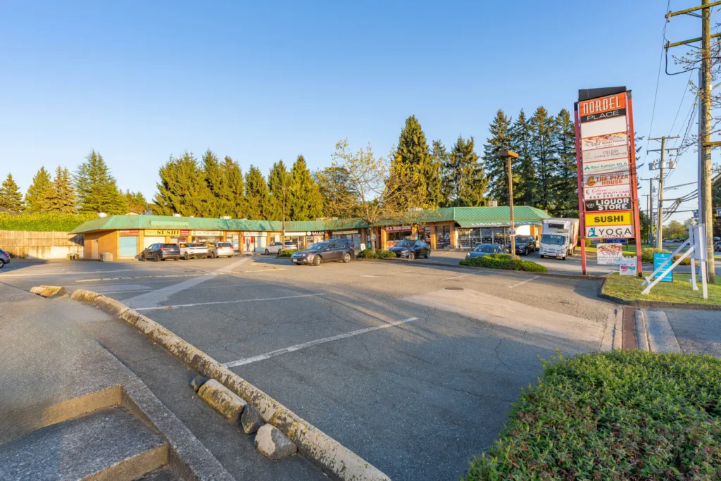 Nordel Place street-level view with pylon sign and retail storefronts along 112 Street