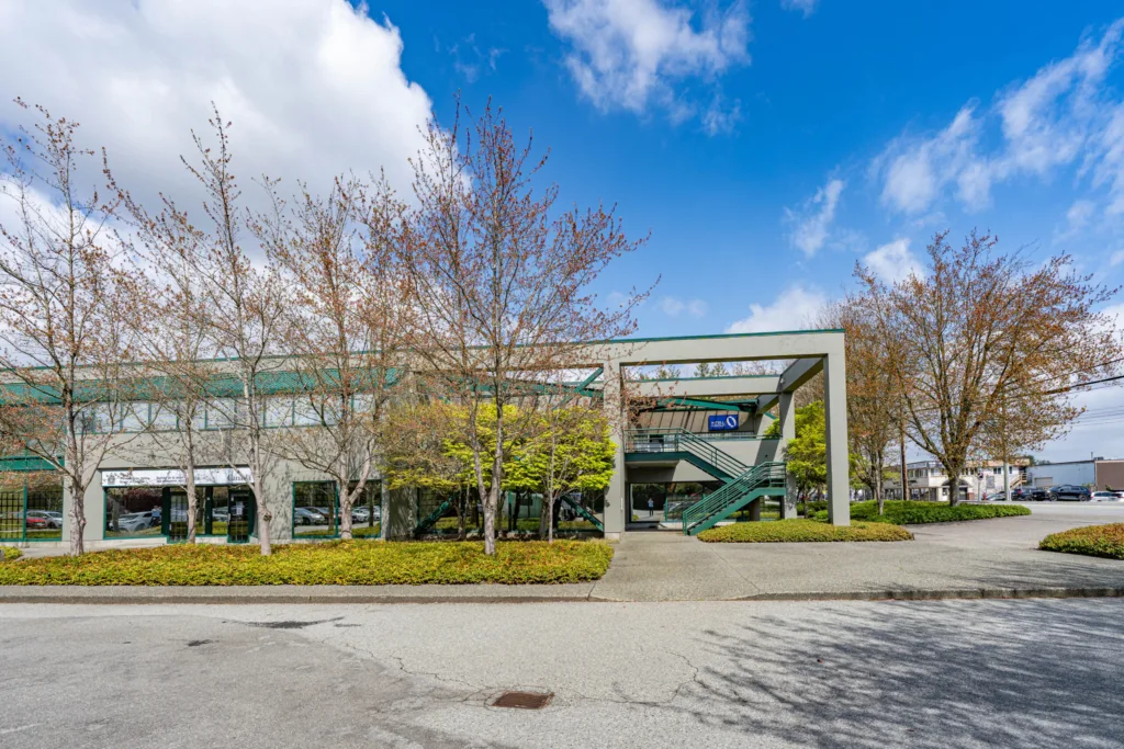 Omnia Centre street-level view with exterior staircase and surface parking