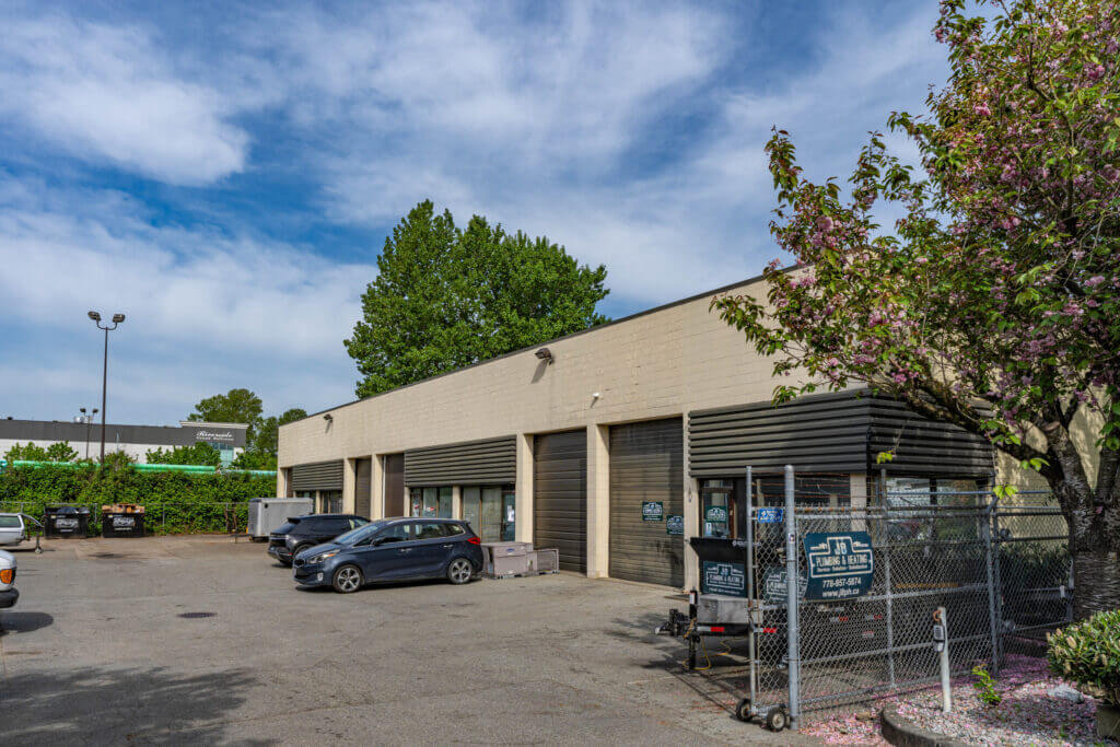 Valmont Building warehouse exterior with surface parking and fenced yard in North Richmond