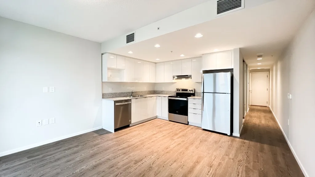 Lelem Village University Blvd Building open-concept kitchen and living area with vinyl plank floors and stainless steel appliances