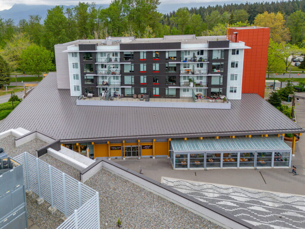 Lelem Village University Blvd Building rear exterior with glass balconies and retail level