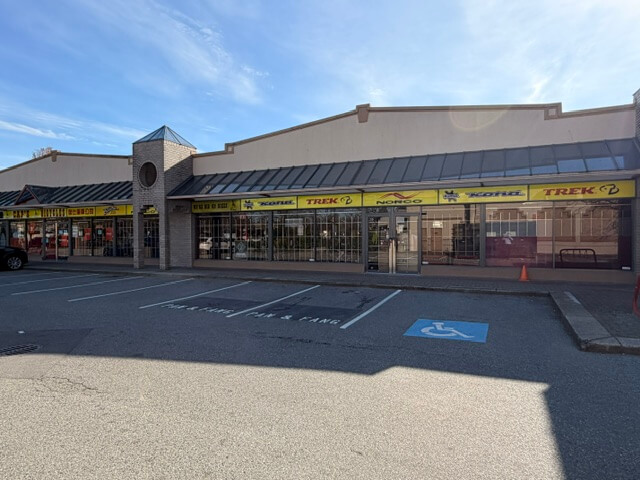 Exterior view of Olympia Centre at 8400-8460 Alexandra Road with parking lot and accessible stalls