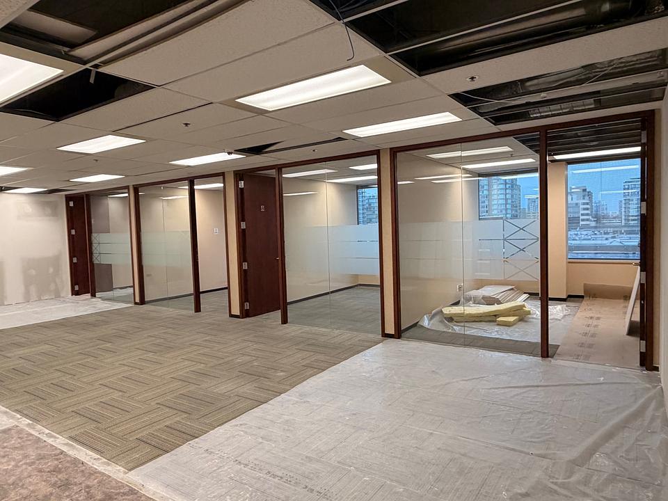 Open work area with glass-walled offices at 5811 Cooney Road Unit S403
