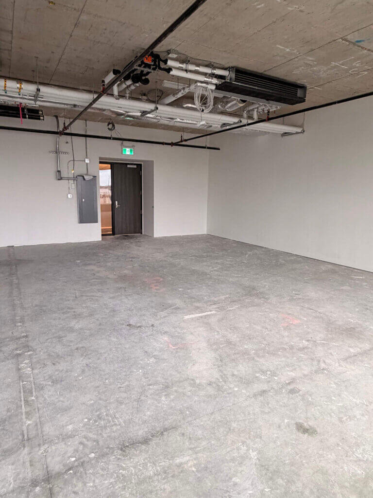 Unfinished office interior with entry door and exposed ceiling at 5599 No. 3 Road Unit 525, Richmond