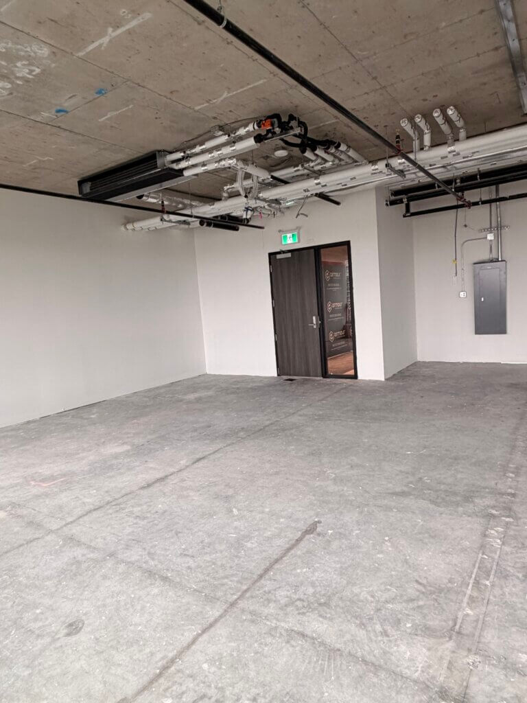 Unfinished office space with entry door and exposed ceiling at 5599 No. 3 Road Unit 530