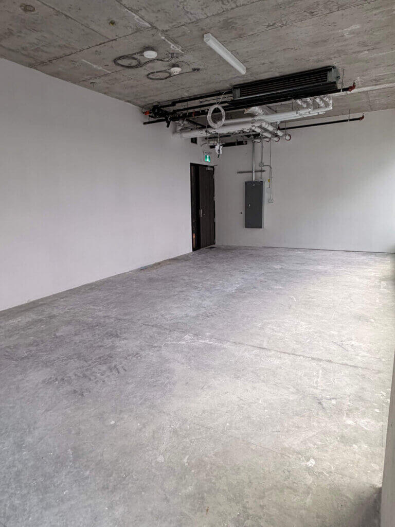 Open-plan office interior with exposed concrete ceiling at 5599 No. 3 Road Unit 705