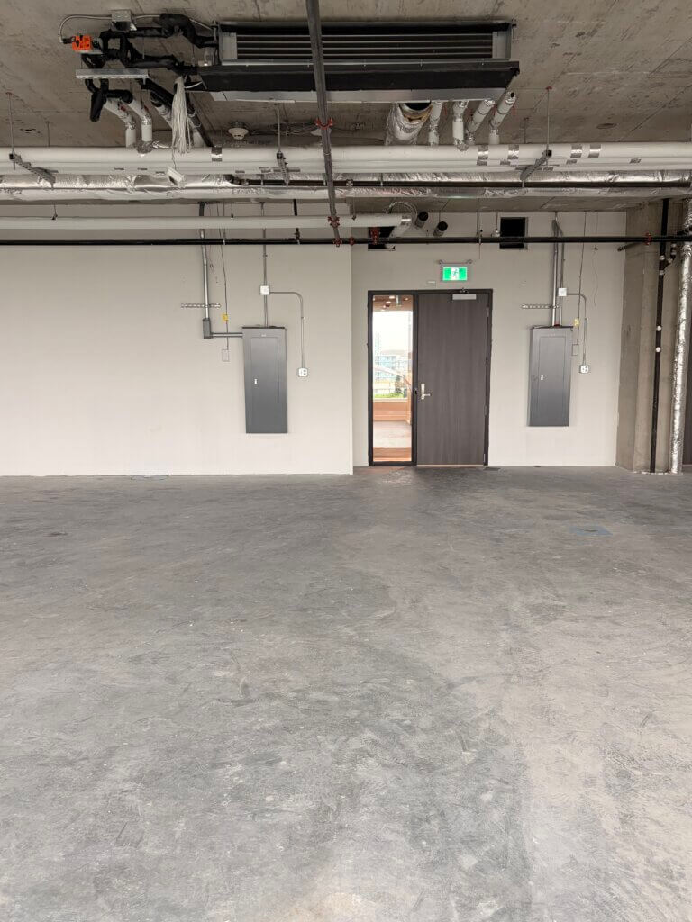 Open shell office space with exposed ceiling and entry door at 5599 No. 3 Road Unit 720