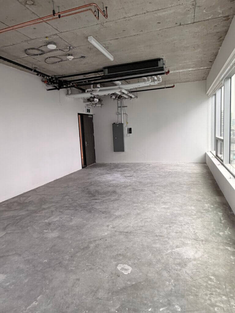 Open-plan office space with exposed concrete ceiling at 5599 No. 3 Road Unit 805